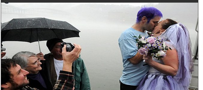 Judy and Adam kissing by the misty Mon River on their wedding day